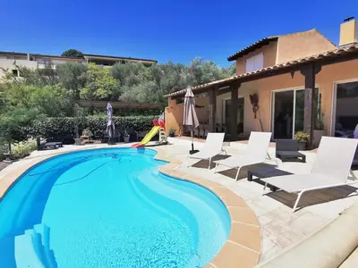 a swimming pool with chairs and a house at Magnifique villa avec piscine à 2 pas du centre d'Aix in Aix-en-Provence