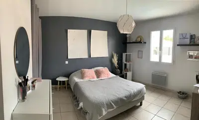 a bedroom with a bed with pink pillows on it at Maison agréable pour vacances réussies in Vernègues