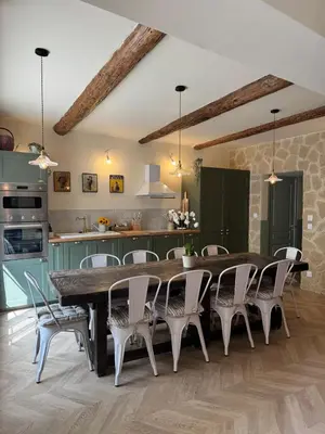 a kitchen and dining room with a large wooden table and chairs at Les Romarins - 5 chambres in Lauris