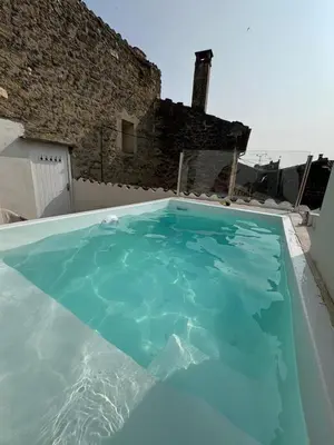 a pool of blue water in front of a building at Les Romarins - 5 chambres in Lauris