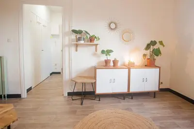 a room with a white cabinet with plants and a mirror at La Mazarine - Studio tout confort - Les Milles proche Aix TGV Marseille in Aix-en-Provence