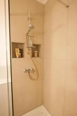 a shower with a shower head in a bathroom at La Mazarine - Studio tout confort - Les Milles proche Aix TGV Marseille in Aix-en-Provence