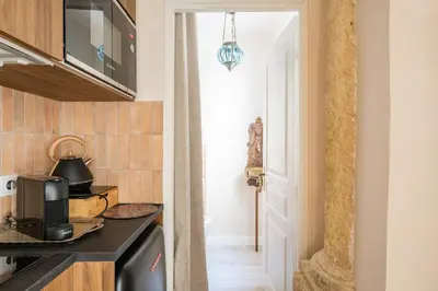 a kitchen with a counter top and a microwave at La Cour Secrète - Suite Riad Balnéo privé Carpentras in Carpentras