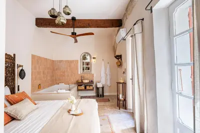 a bedroom with a bed and a tub in a room at La Cour Secrète - Suite Riad Balnéo privé Carpentras in Carpentras