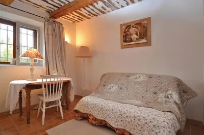 a bedroom with a bed and a table and a chair at Mas Bosca Brun in Cheval-Blanc