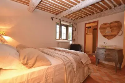 a bedroom with a bed and a desk and a window at Mas Bosca Brun in Cheval-Blanc