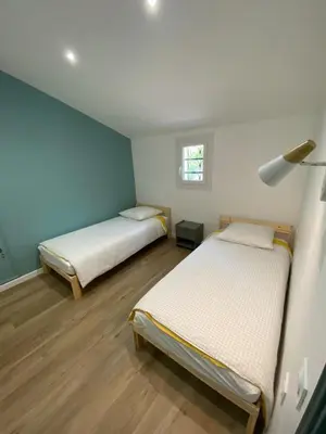 two beds in a room with blue walls and wooden floors at Maison Aix-en-Provence in Aix-en-Provence