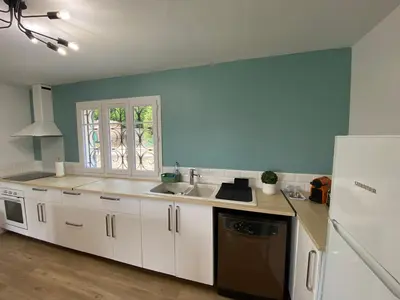 a kitchen with white cabinets and a sink and a window at Maison Aix-en-Provence in Aix-en-Provence