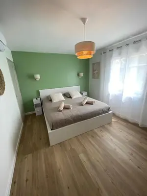 a bedroom with a bed and a green wall at Maison Aix-en-Provence in Aix-en-Provence