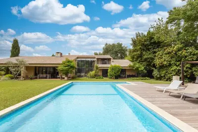 a swimming pool in front of a house at Villa des Pres in Eyragues