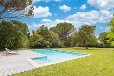 a swimming pool in a yard with a deck at Villa des Pres in Eyragues