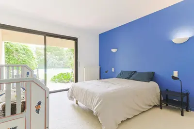 a bedroom with a blue wall and a bed at Villa des Pres in Eyragues