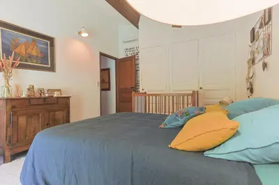 a bedroom with a bed with blue sheets and yellow pillows at Villa des Pres in Eyragues