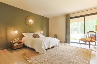 a bedroom with a bed and a large window at Villa des Pres in Eyragues