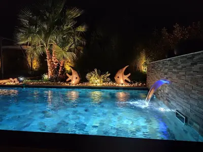 a swimming pool at night with a water fountain at Chamarte villa piscine chauffées jardin clôturé Aix en Provence in Aix-en-Provence