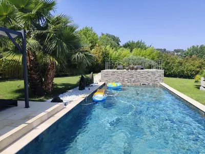 a swimming pool with two inflatables in a yard at Chamarte villa piscine chauffées jardin clôturé Aix en Provence in Aix-en-Provence