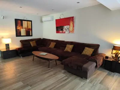 a living room with a brown couch and a table at Chamarte villa piscine chauffées jardin clôturé Aix en Provence in Aix-en-Provence