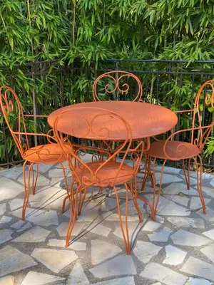 a wooden table and chairs sitting around a table and chairs at La Pasclapierre in Orgon
