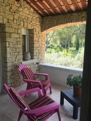 two chairs and a table on a porch at La Pasclapierre in Orgon