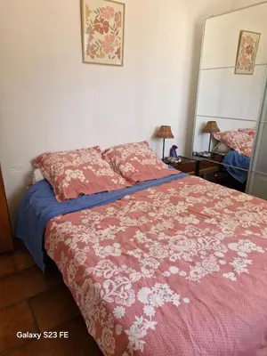 a bedroom with a bed with a red comforter at Villa Le Pin in Rognes
