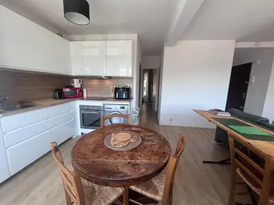 a small kitchen with a wooden table and chairs at Aix centre - Appartement Cosy avec Terrasse et Clim in Aix-en-Provence