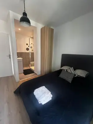 a bedroom with a large bed with a blue blanket at Aix centre - Appartement Cosy avec Terrasse et Clim in Aix-en-Provence