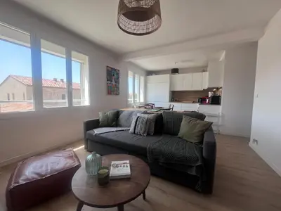 a living room with a couch and a table at Aix centre - Appartement Cosy avec Terrasse et Clim in Aix-en-Provence
