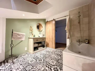 a bathroom with a tub and a sink at Villa 7 chambres, piscine et jardins privés, pas de voisins in Le Thor