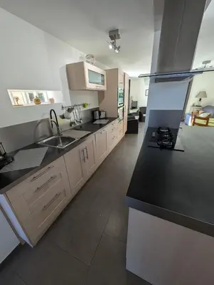 a kitchen with black counter tops and white cabinets at Villa 7 chambres, piscine et jardins privés, pas de voisins in Le Thor