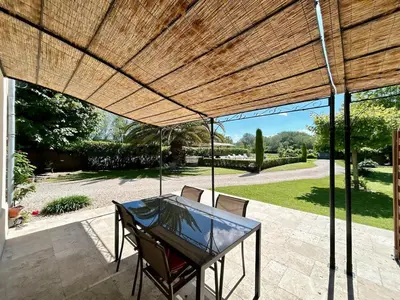 a patio with a table and chairs under a wooden pergola at Villa 7 chambres, piscine et jardins privés, pas de voisins in Le Thor