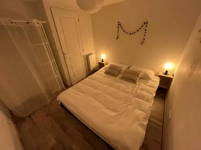 a bedroom with a large white bed with two pillows at appartement avec piscine in Gargas