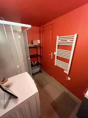 a room with a red wall and a white radiator at appartement avec piscine in Gargas