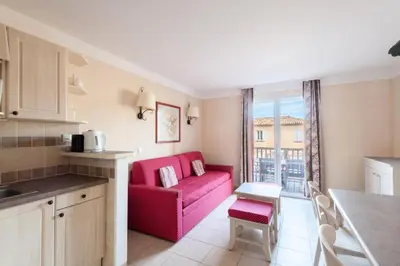 a kitchen and a living room with a red couch at Les Coteaux de Pont Royal en Provence - maeva Home - Maison 3 pièces 6 personnes - Sélection MAE-9993 in Mallemort