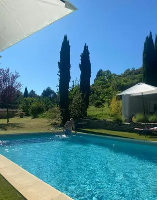 a man is standing in a swimming pool at Provencal Villa With Panoramic Views In Luberon in Apt