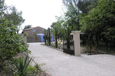 a gate in a driveway with a house in the background at Mas provençal - Beautiful Provencal farmhouse, heated pool in Murs