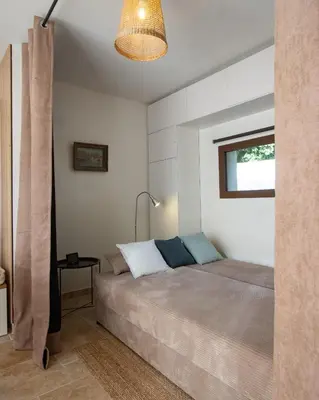 a bedroom with a bed and a lamp and a window at Cabanon Lourmarin in Lourmarin