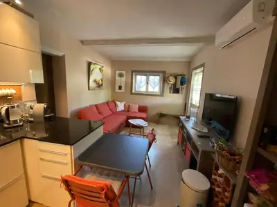 a kitchen and a living room with a red couch at Cabanon Lourmarin in Lourmarin