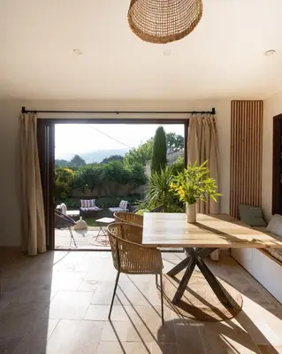 a living room with a table and a large window at Cabanon Lourmarin in Lourmarin