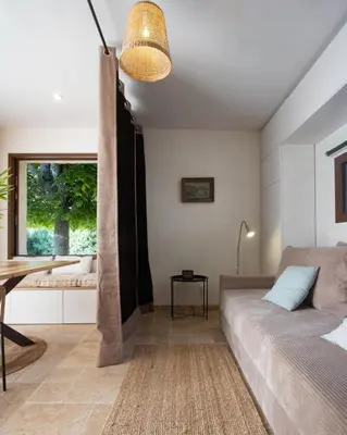 a bedroom with a bed and a table and a window at Cabanon Lourmarin in Lourmarin