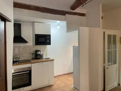 a kitchen with white cabinets and a stove top oven at Plaisir de vacances in Aix-en-Provence