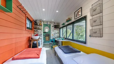 a room with two beds and a sink in it at La roulotte de Valou in Noves