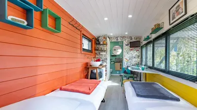 a room with two beds and a wall of wood at La roulotte de Valou in Noves