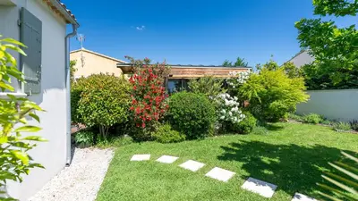 a backyard with a yard with plants and flowers at La roulotte de Valou in Noves