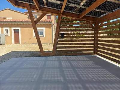 a covered patio in front of a house at Gite au calme, sur domaine vinicole avec piscine chauffée partagée idéal rando et vélo in Mormoiron