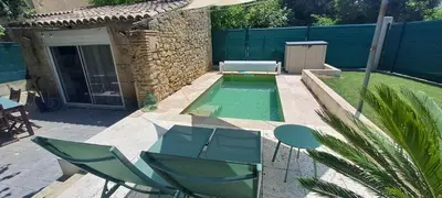 a backyard with a pool with a table and chairs at Location Le Tilleul in Pélissanne