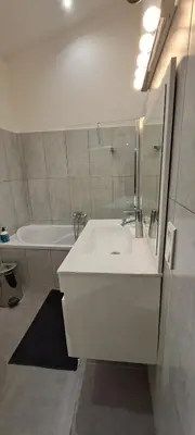 a white bathroom with a sink and a tub at Location Le Tilleul in Pélissanne