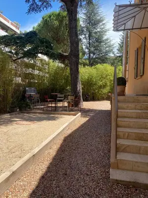 a patio with a tree and a table and chairs at Saint-Jean-des-Cèdres in Aix-en-Provence