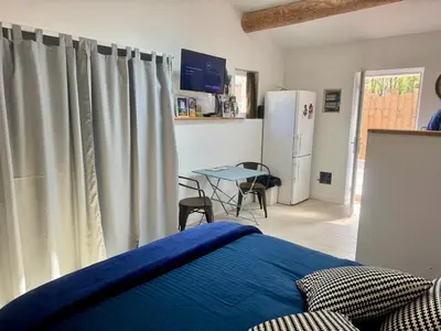 a bedroom with a bed and a table and a refrigerator at Maset Lou Pitchoun in Saint-Rémy-de-Provence