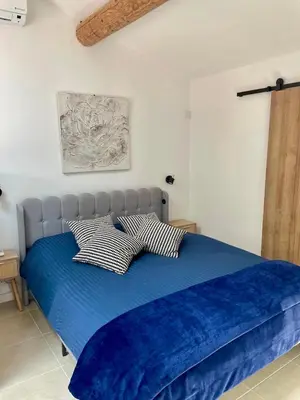 a bedroom with a blue bed with two pillows at Maset Lou Pitchoun in Saint-Rémy-de-Provence