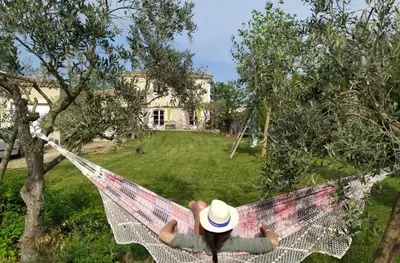 a person laying on a hammock in a yard at Belle bastide provençale in Noves